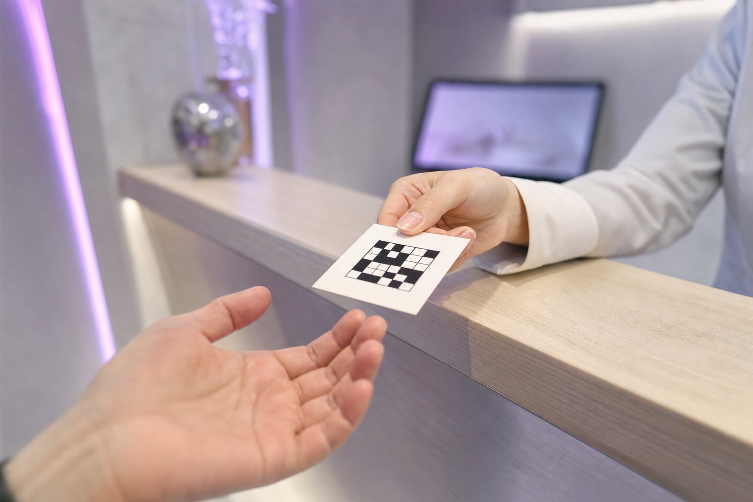 受付でQRコードのカードを手渡す手元